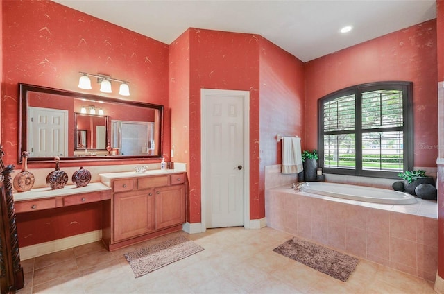 bathroom featuring vanity, tiled bath, and tile patterned flooring