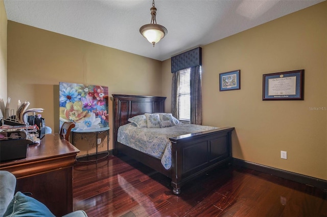 bedroom with dark wood-type flooring and a textured ceiling