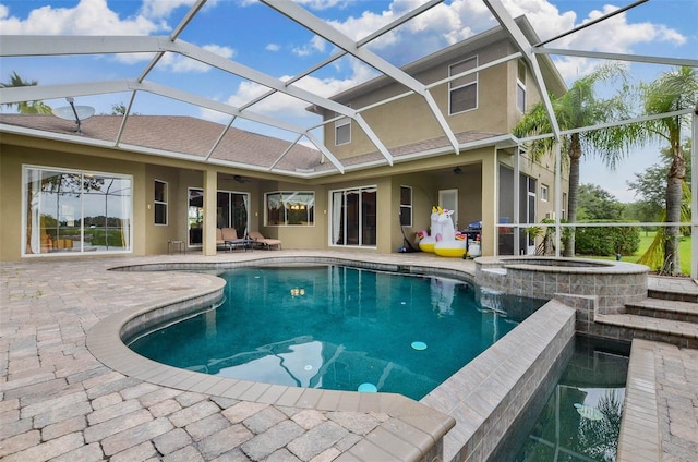 view of pool featuring glass enclosure, a patio area, and an in ground hot tub