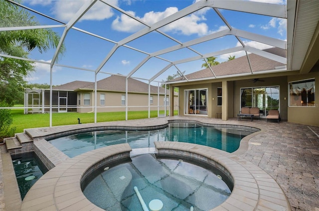 view of swimming pool featuring an in ground hot tub, a patio area, glass enclosure, ceiling fan, and a yard