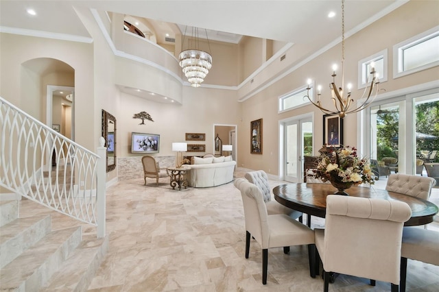 dining area with french doors, crown molding, a high ceiling, and a chandelier