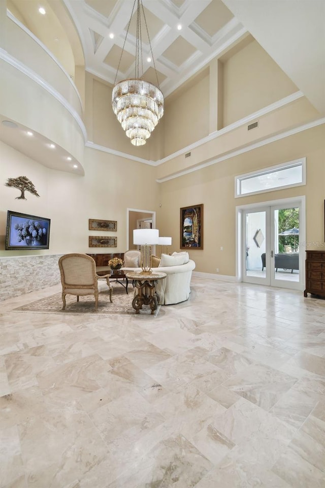 living room with coffered ceiling, a chandelier, a high ceiling, and french doors