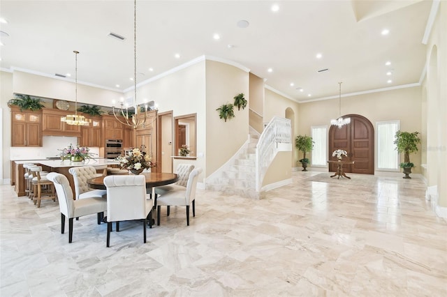 dining room featuring a high ceiling, an inviting chandelier, and crown molding