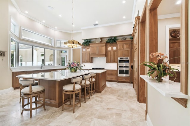 kitchen featuring a breakfast bar, a spacious island, decorative light fixtures, appliances with stainless steel finishes, and a notable chandelier