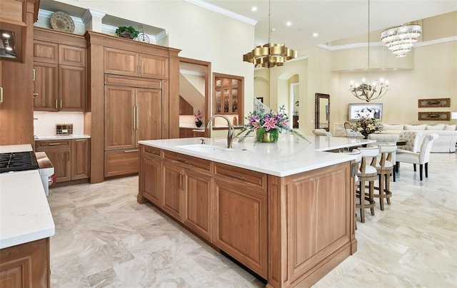 kitchen with sink, paneled fridge, crown molding, a spacious island, and pendant lighting