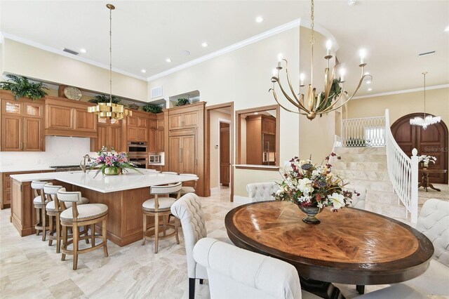 kitchen featuring a kitchen bar, a large island, stainless steel double oven, and hanging light fixtures