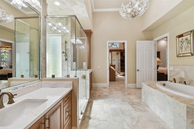 bathroom featuring separate shower and tub, vanity, ornamental molding, and a notable chandelier