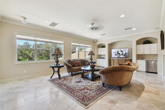 living room featuring built in shelves, ceiling fan, ornamental molding, and sink