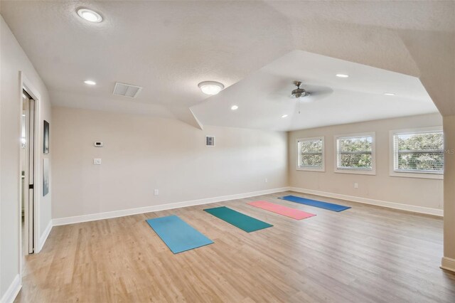 workout room featuring ceiling fan, light hardwood / wood-style flooring, basketball court, lofted ceiling, and a textured ceiling