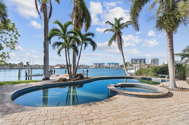 view of pool featuring a view of city, a water view, a pool with connected hot tub, and a boat dock