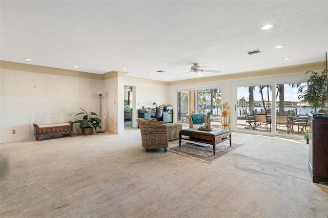 living area featuring ceiling fan, recessed lighting, visible vents, and a textured ceiling