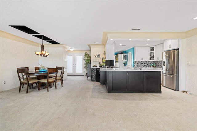 kitchen with visible vents, french doors, white cabinets, stainless steel fridge with ice dispenser, and light countertops