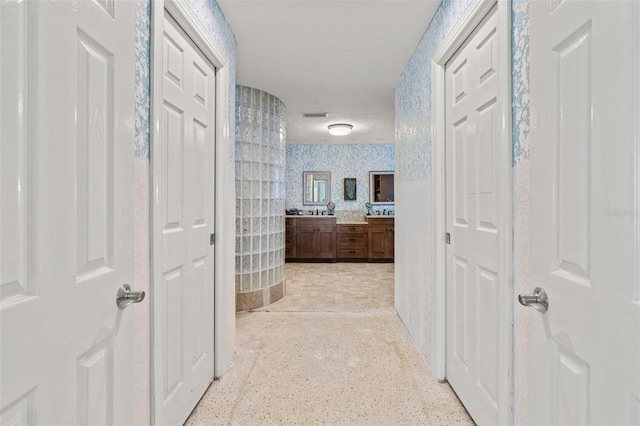 corridor featuring visible vents and wallpapered walls