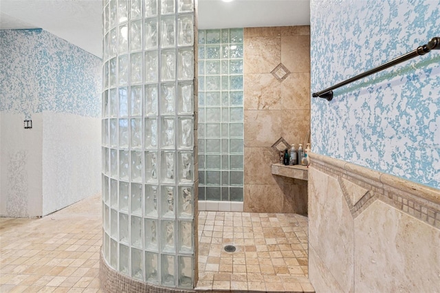 bathroom with walk in shower, tile patterned floors, and tile walls