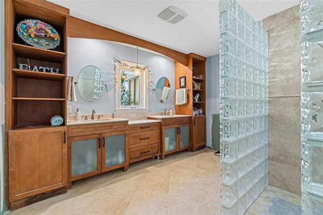 bathroom featuring vanity and tiled shower