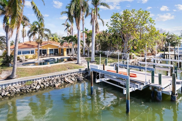 dock area featuring boat lift, an outdoor pool, and a water view