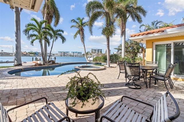 view of pool featuring a patio, an in ground hot tub, and a water view