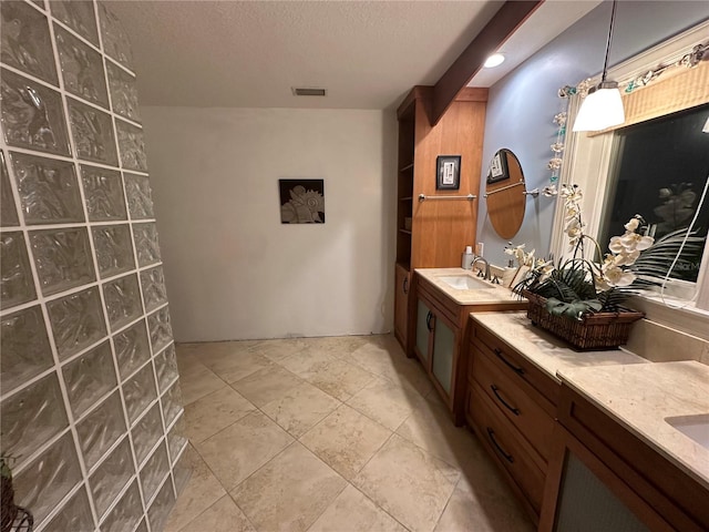 full bathroom with tile patterned floors, visible vents, a textured ceiling, and vanity