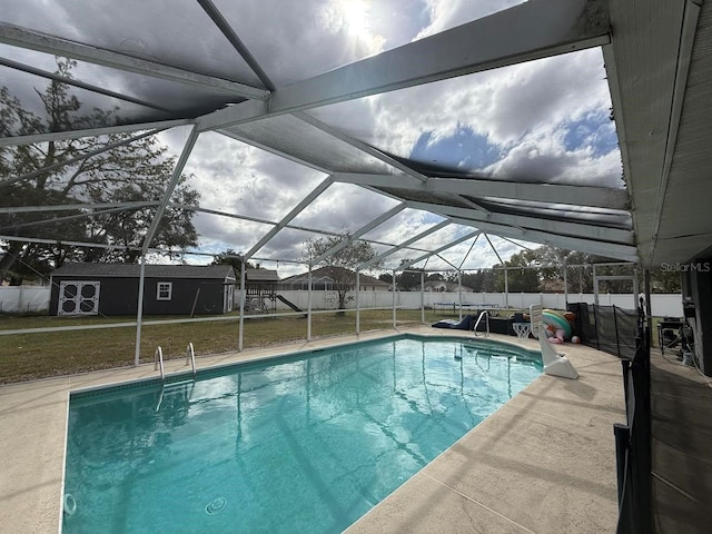 view of pool featuring a fenced in pool, a yard, a fenced backyard, an outdoor structure, and a lanai