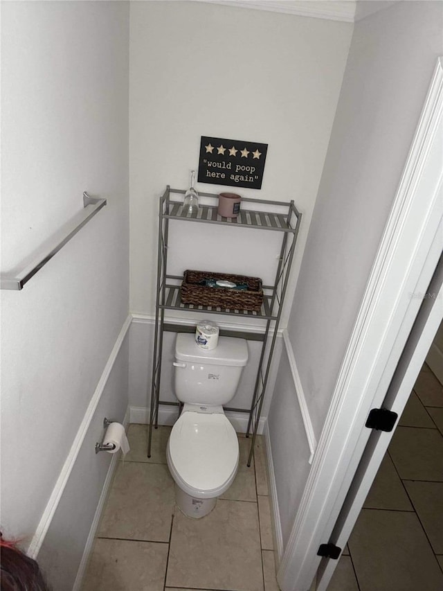 bathroom featuring tile patterned flooring, toilet, and baseboards