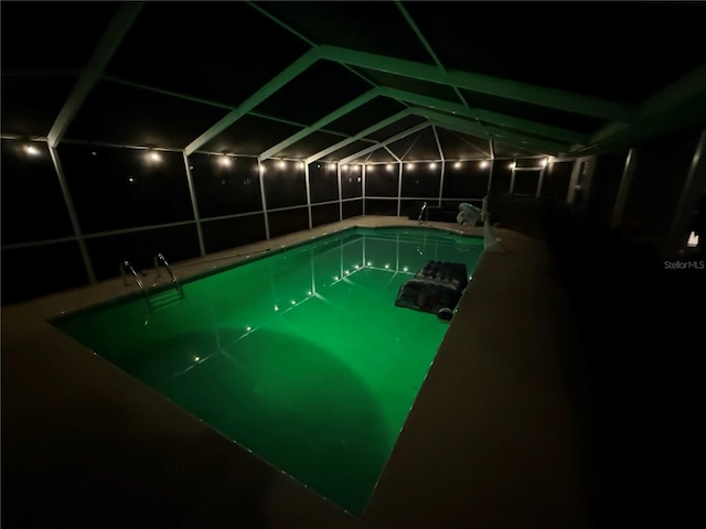 pool at twilight featuring a lanai and an outdoor pool