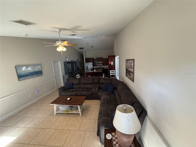 living area with light tile patterned floors, baseboards, visible vents, ceiling fan, and vaulted ceiling