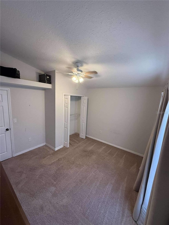 unfurnished bedroom featuring baseboards, ceiling fan, a closet, a textured ceiling, and carpet flooring