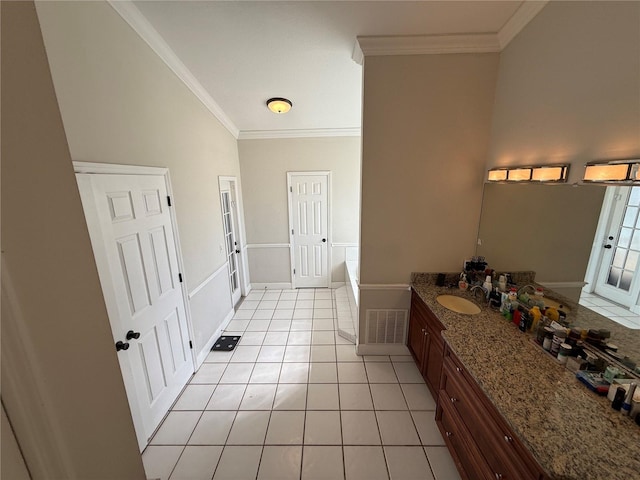 bathroom featuring vanity, a garden tub, visible vents, tile patterned flooring, and crown molding