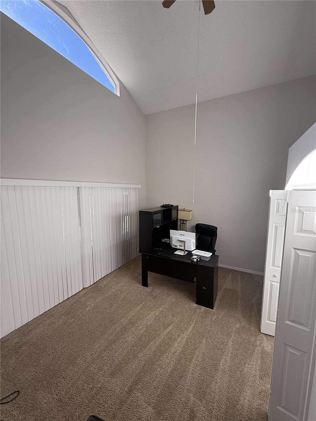 carpeted office space featuring a textured ceiling, a ceiling fan, and vaulted ceiling