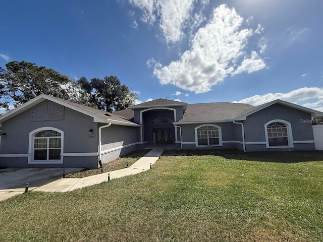 ranch-style house featuring stucco siding, a garage, and a front yard