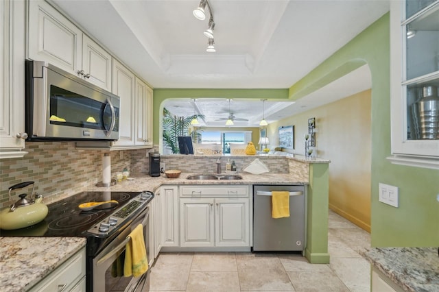 kitchen with white cabinets, appliances with stainless steel finishes, a raised ceiling, and ceiling fan