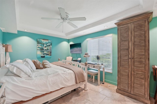 tiled bedroom with a tray ceiling and ceiling fan