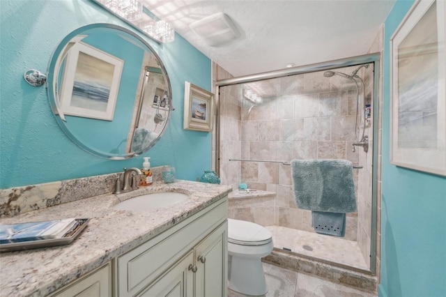 bathroom featuring vanity, a shower with shower door, and toilet