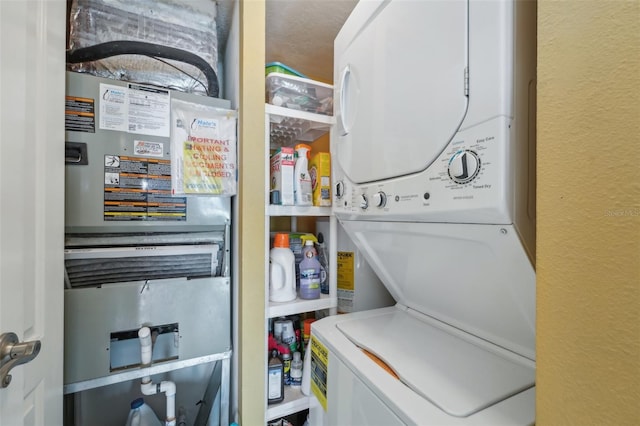 washroom with a textured ceiling and stacked washer and dryer