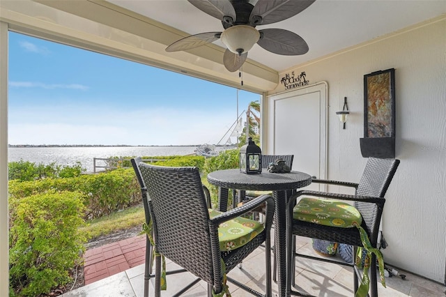 exterior space featuring ceiling fan and a water view