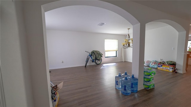 spare room with dark hardwood / wood-style flooring and a chandelier