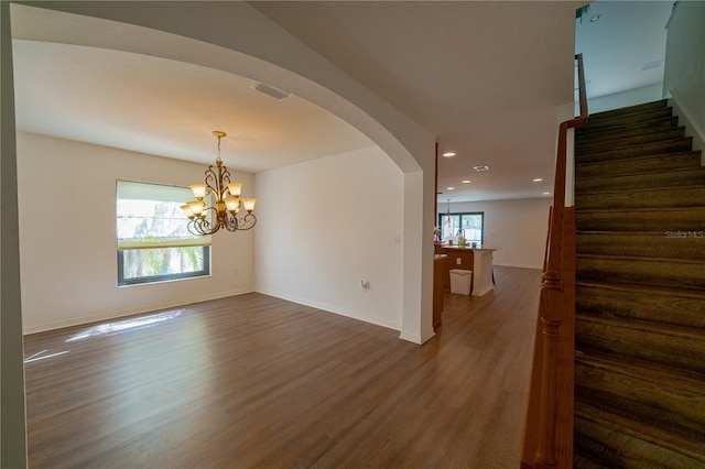 unfurnished room with hardwood / wood-style flooring, plenty of natural light, and a notable chandelier