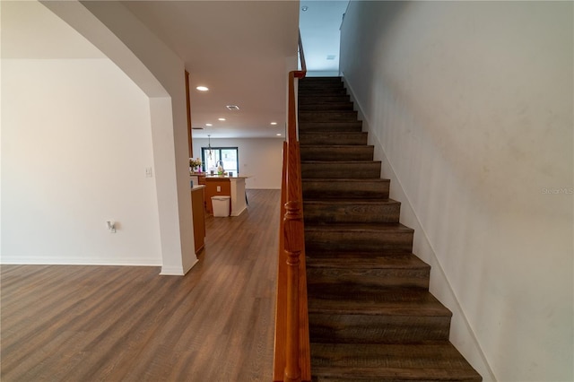 stairs with a chandelier and wood-type flooring