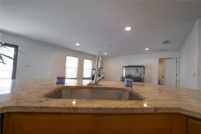 kitchen featuring sink and light stone counters