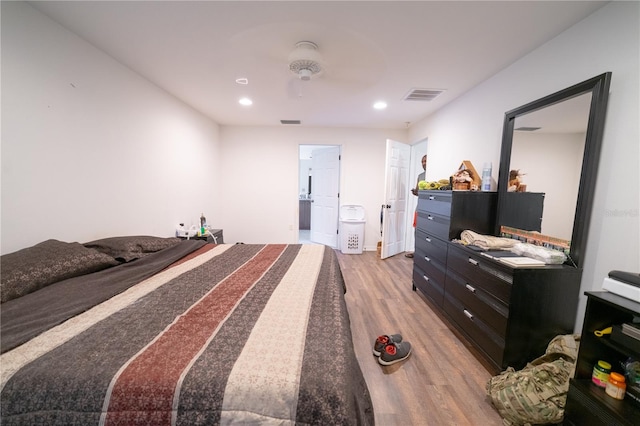 bedroom with light hardwood / wood-style floors and ensuite bathroom