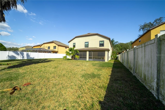 back of house with a lawn and a sunroom