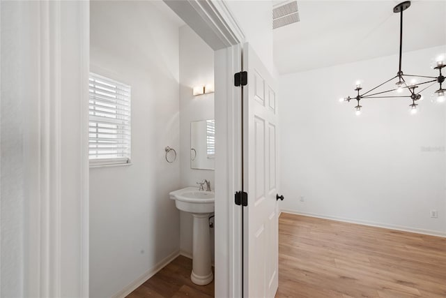 bathroom featuring hardwood / wood-style floors, sink, and an inviting chandelier