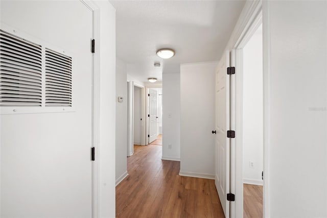 hallway featuring a textured ceiling and light hardwood / wood-style flooring