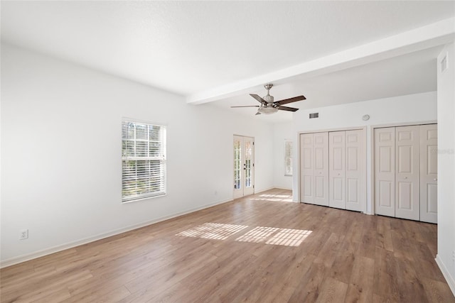 unfurnished bedroom featuring multiple closets, ceiling fan, beamed ceiling, and light hardwood / wood-style floors