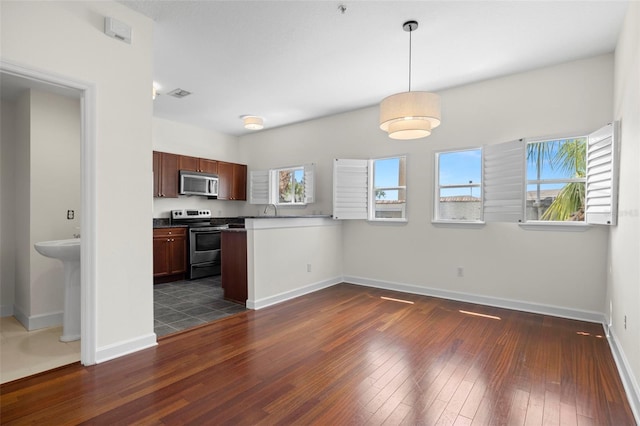 403 S Oregon Ave, Tampa, FL 33606 - kitchen featuring a peninsula, appliances with stainless steel finishes, dark wood-style flooring, and baseboards