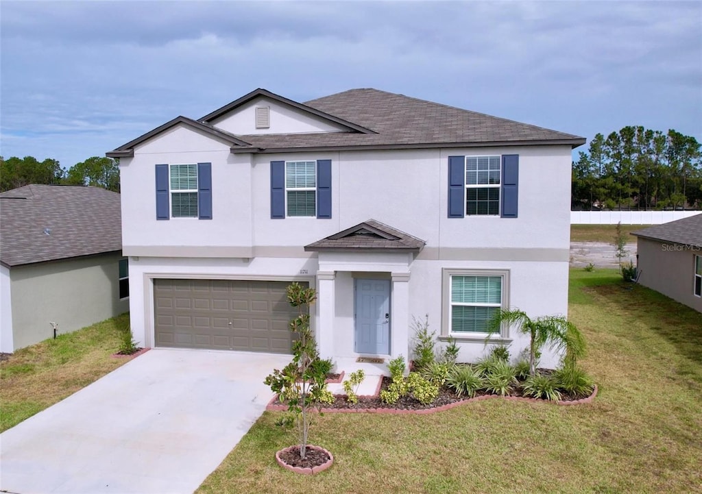 view of front of house featuring a garage and a front lawn