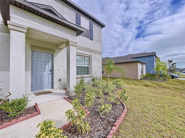 view of exterior entry featuring a yard