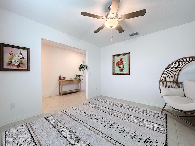 living area featuring light tile patterned floors and ceiling fan