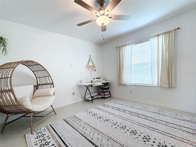 sitting room with ceiling fan and light tile patterned floors