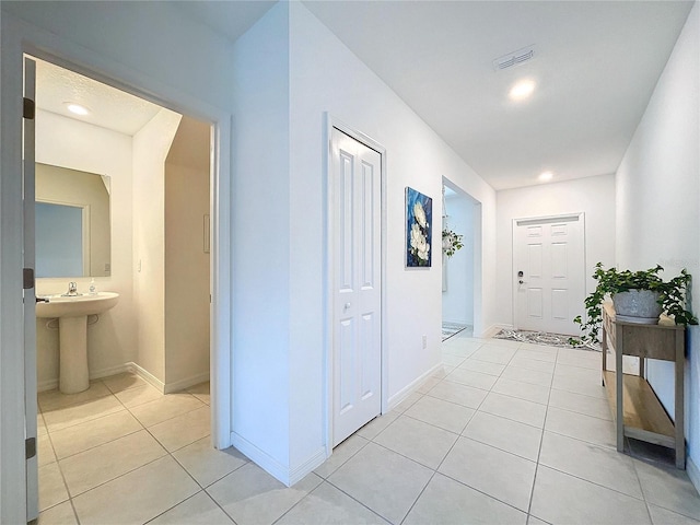 corridor with sink and light tile patterned flooring